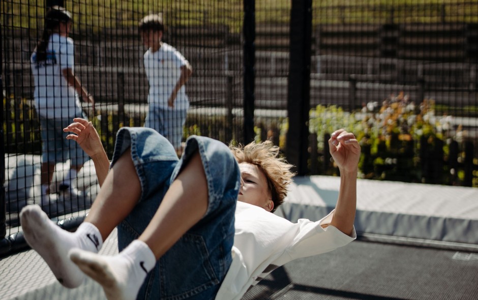 Fr&ouml;hlich springende Kinder auf einer Outdoor-Trampolinanlage im Hotelgarten in Flachau