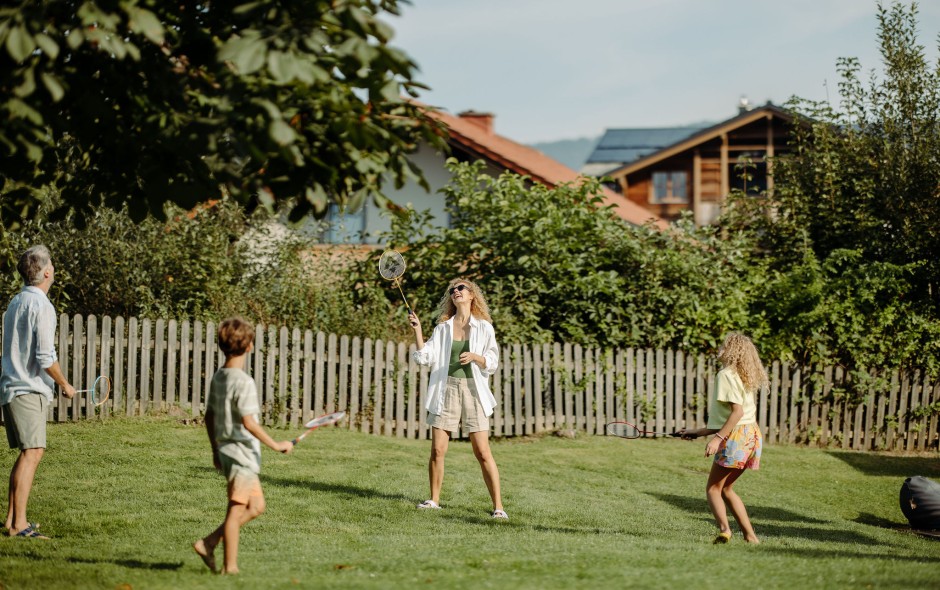 Familie spielt Federball im gro&szlig;en Garten des Resl Resort in Flachau