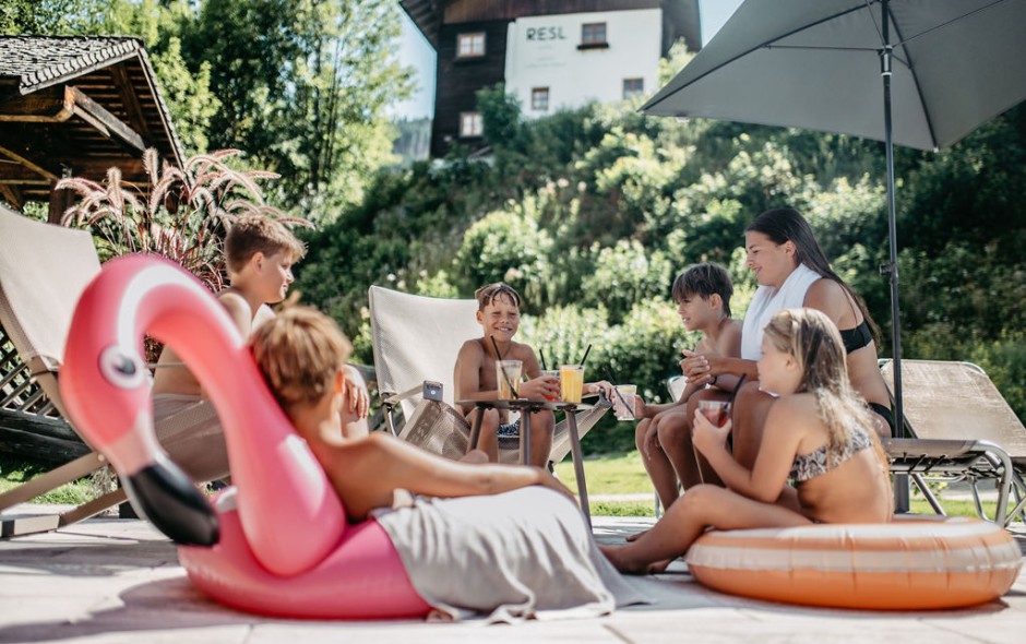 Kinder lachen und trinken Getr&auml;nke am Pool