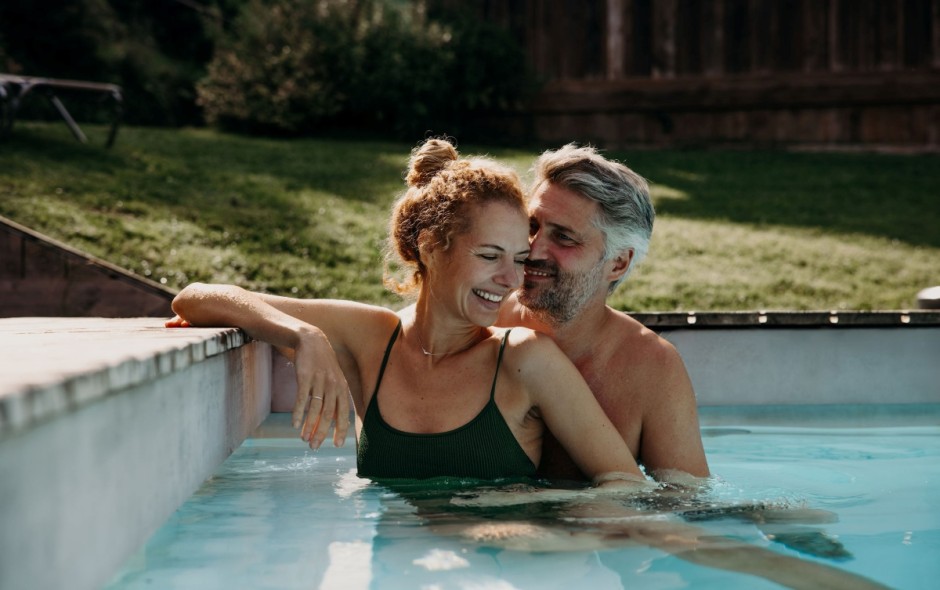 Paar lacht gemeinsam im Pool des Hotel Resl Resort in Flachau und genie&szlig;t den Urlaub